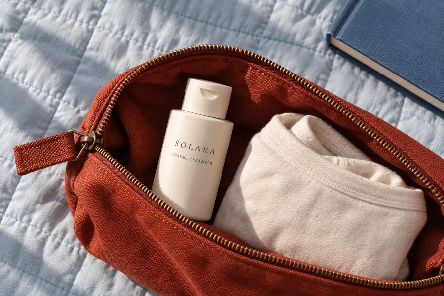 Solara Travel Cleanser packed beside a green wash bag